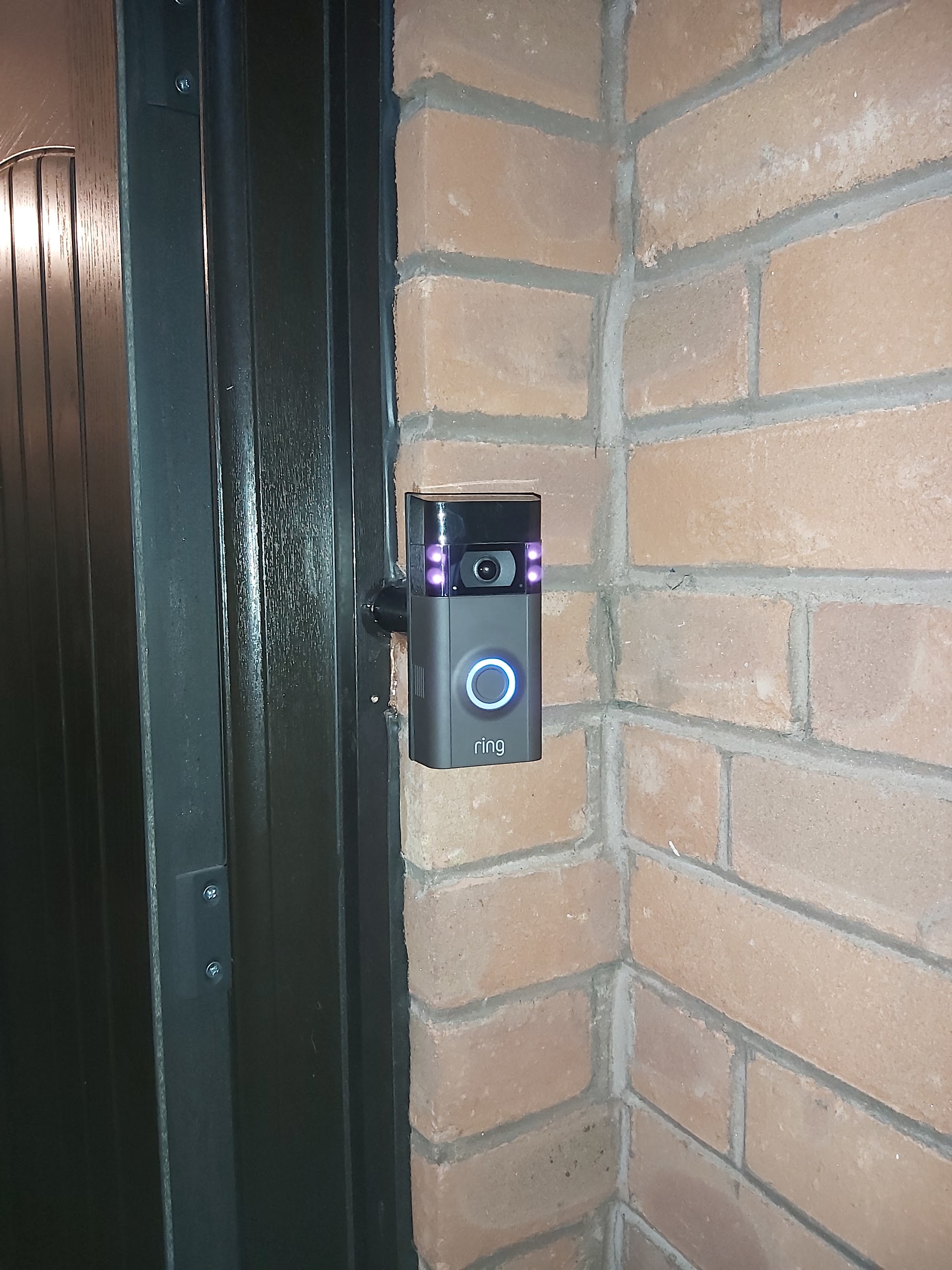 A video doorbell fitted on a brick door reveal